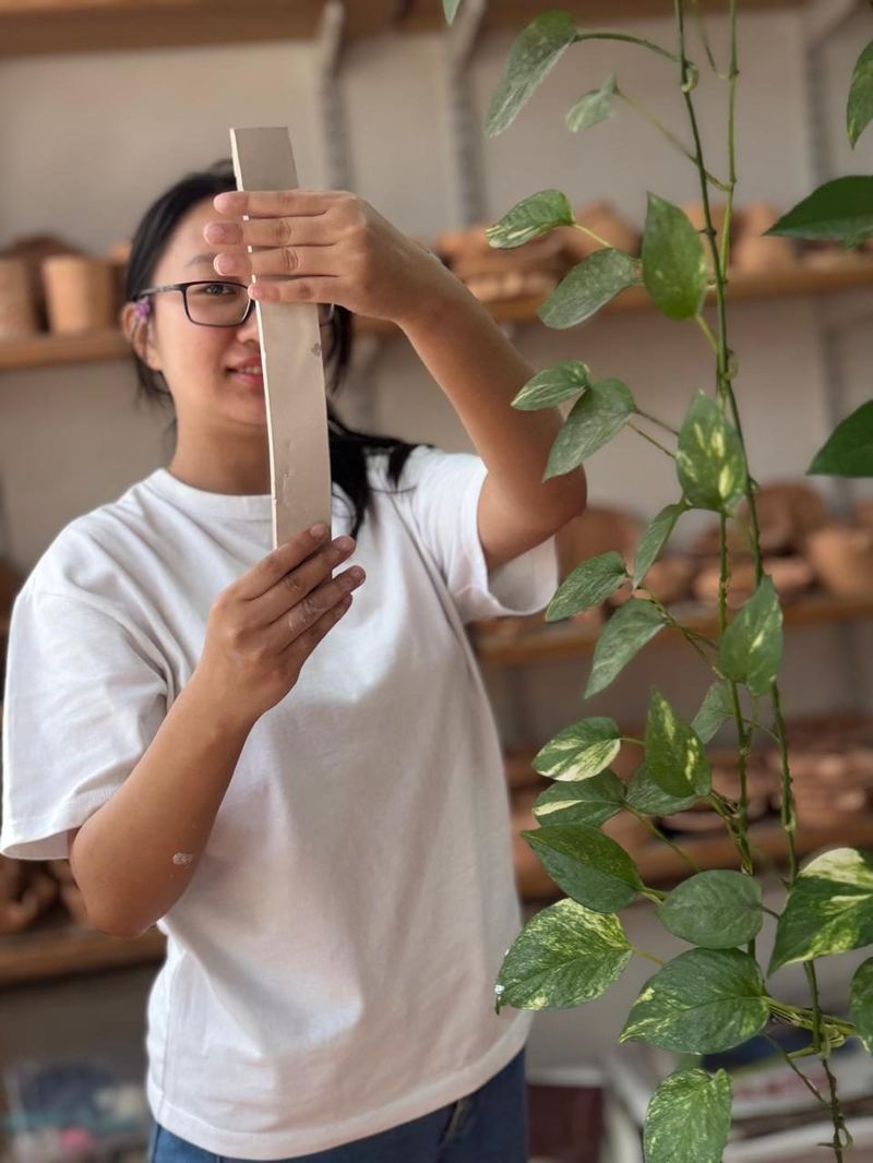 Student measuring clay at Mudcast