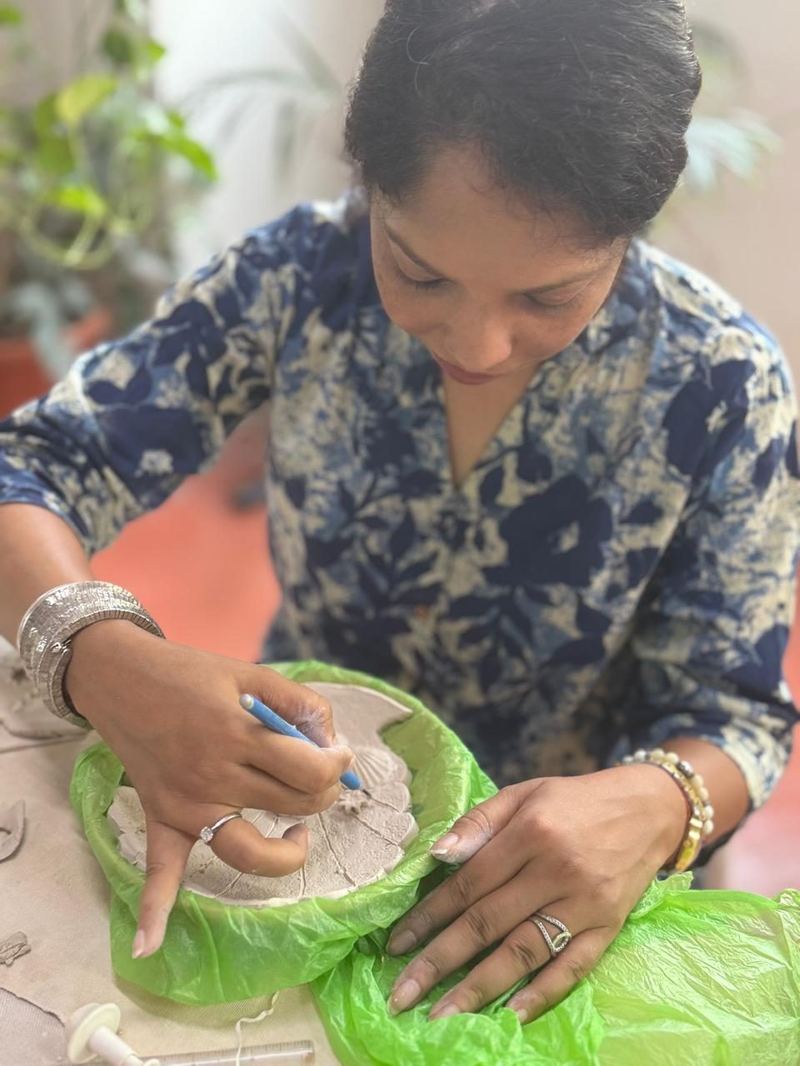 Student with clay plate at Mudcast Pottery