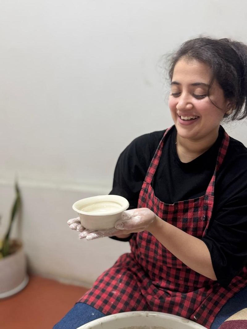 Student carving clay at Mudcast Pottery