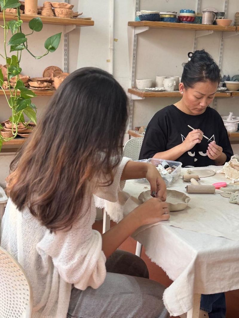 Student shaping clay at Mudcast